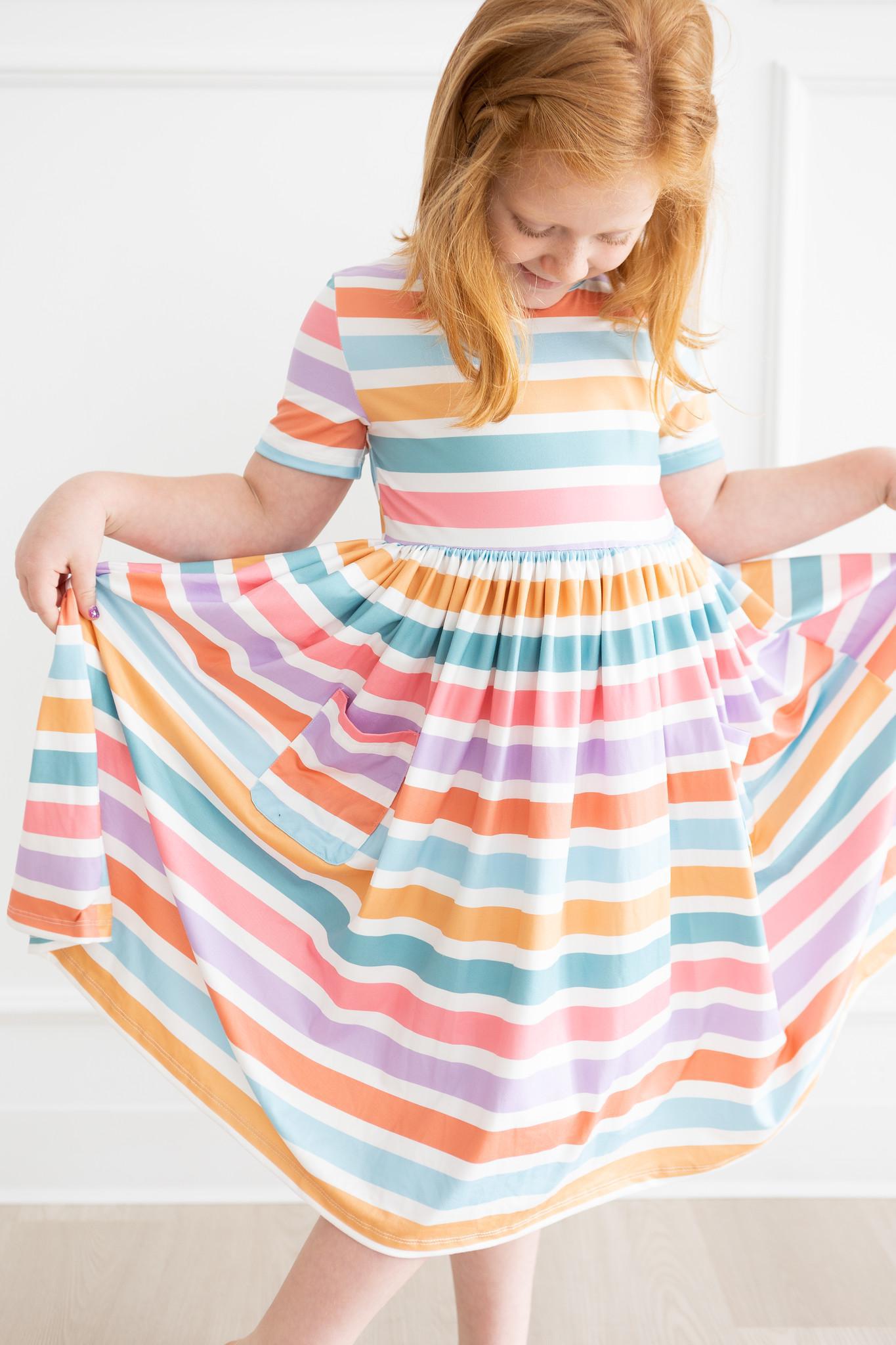 girl twirling in pastel striped dress during springtime