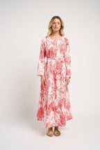 Woman wearing a red and white patterned dress on a white background