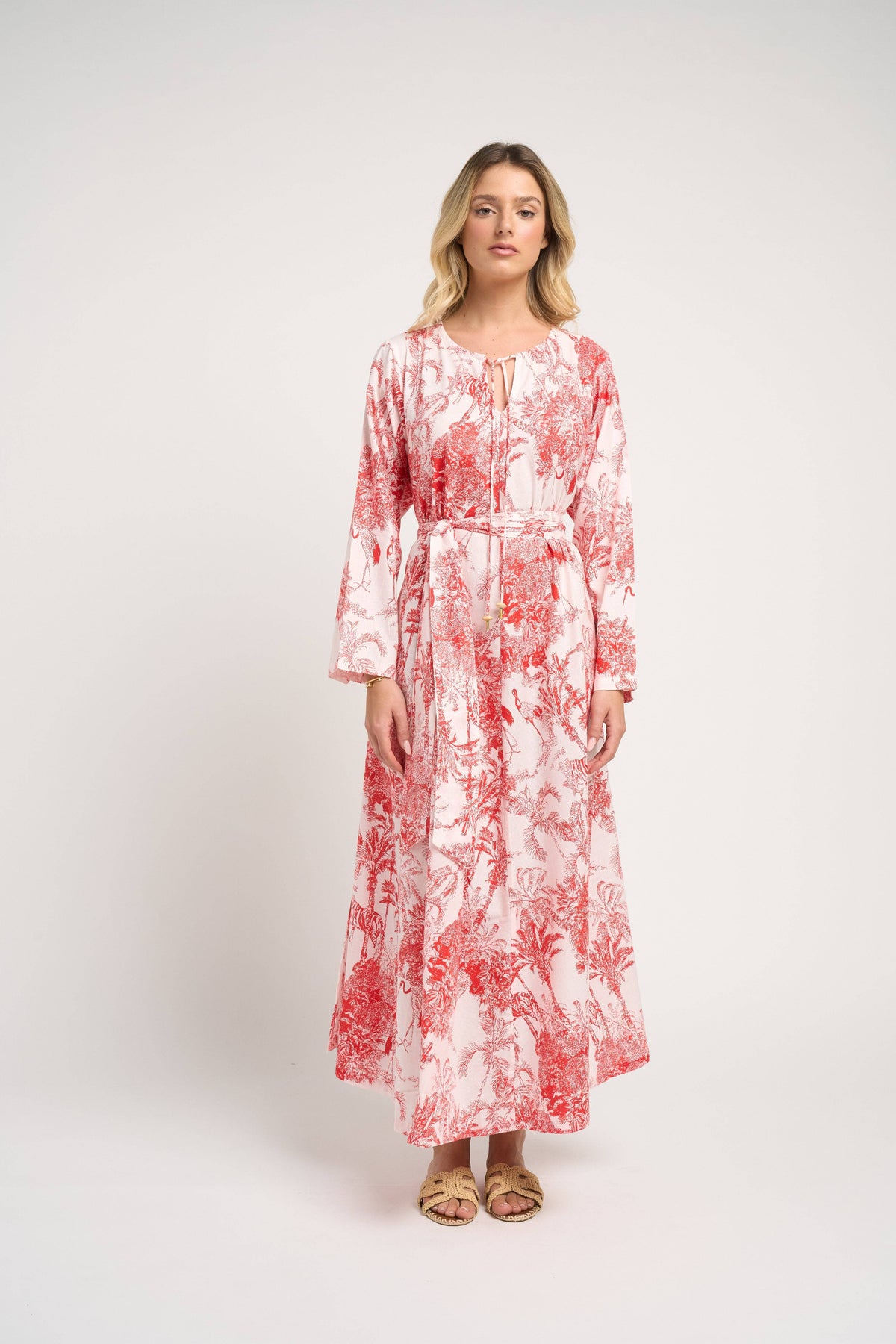 Woman wearing a red and white patterned dress on a white background