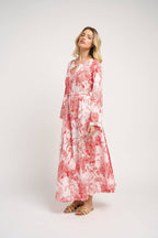 Woman wearing a red and white floral dress on a white background