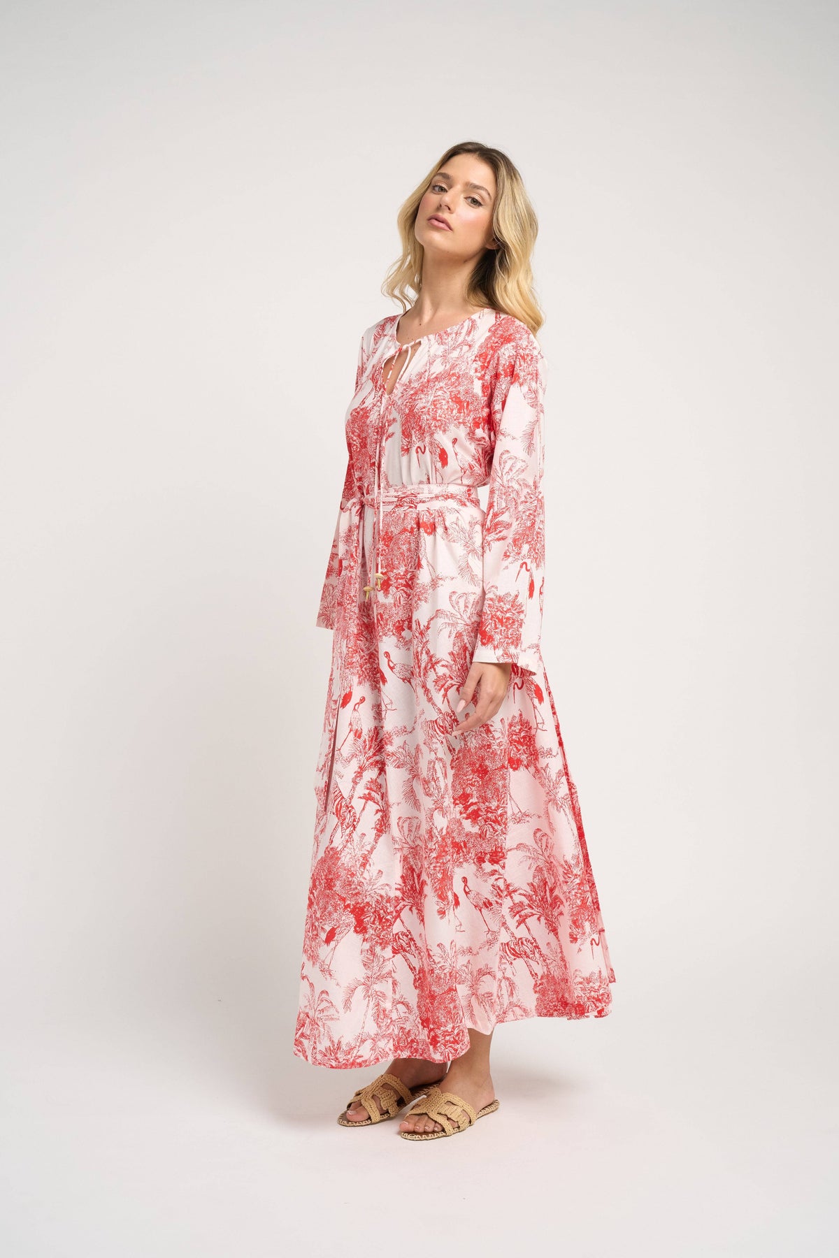 Woman wearing a red and white floral dress on a white background