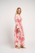 Woman wearing a red and white floral dress on a white background