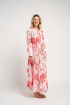 Woman wearing a red and white floral dress on a white background