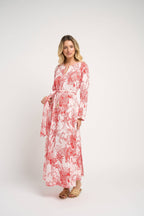 Woman wearing a red and white floral dress on a white background