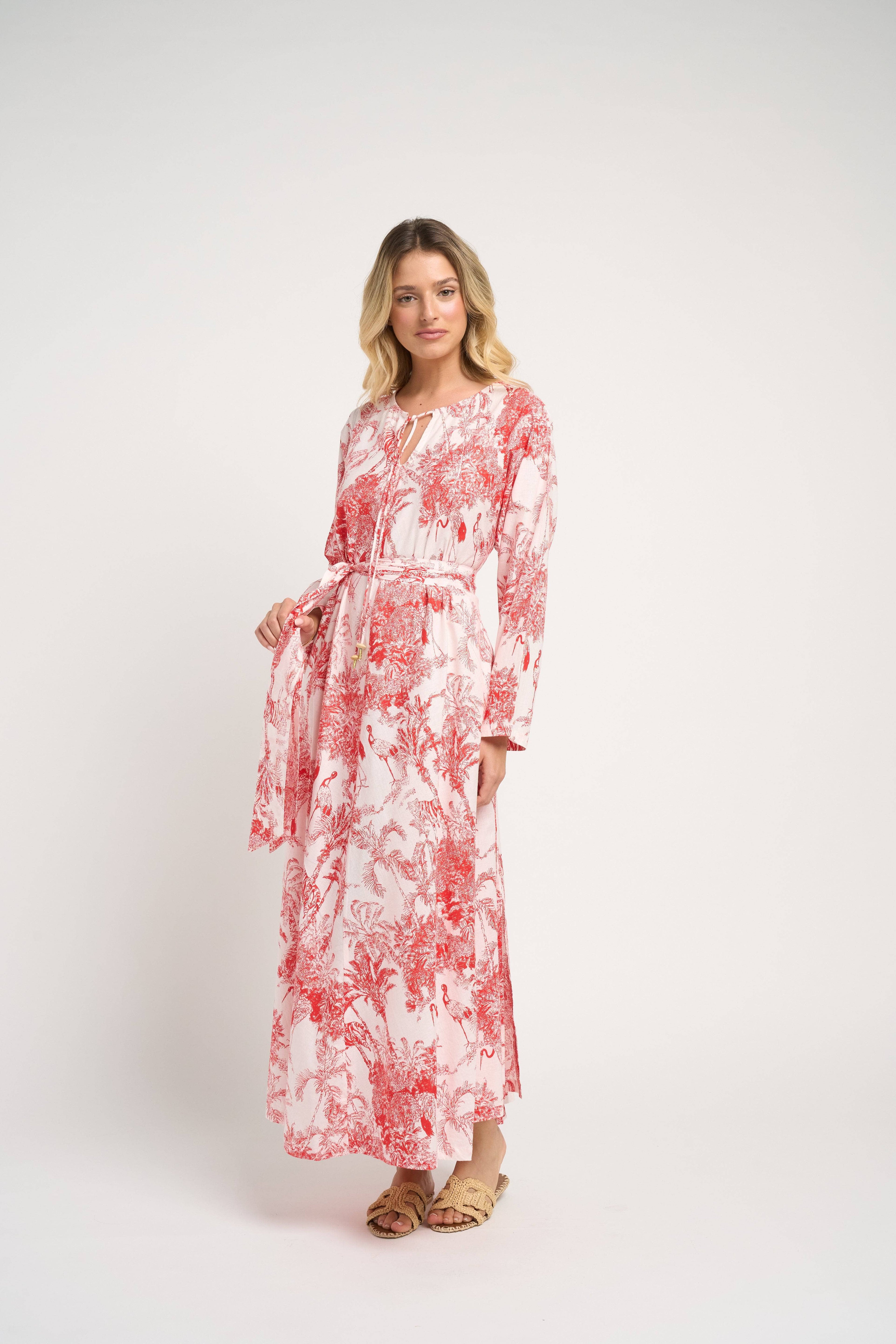 Woman wearing a red and white floral dress on a white background