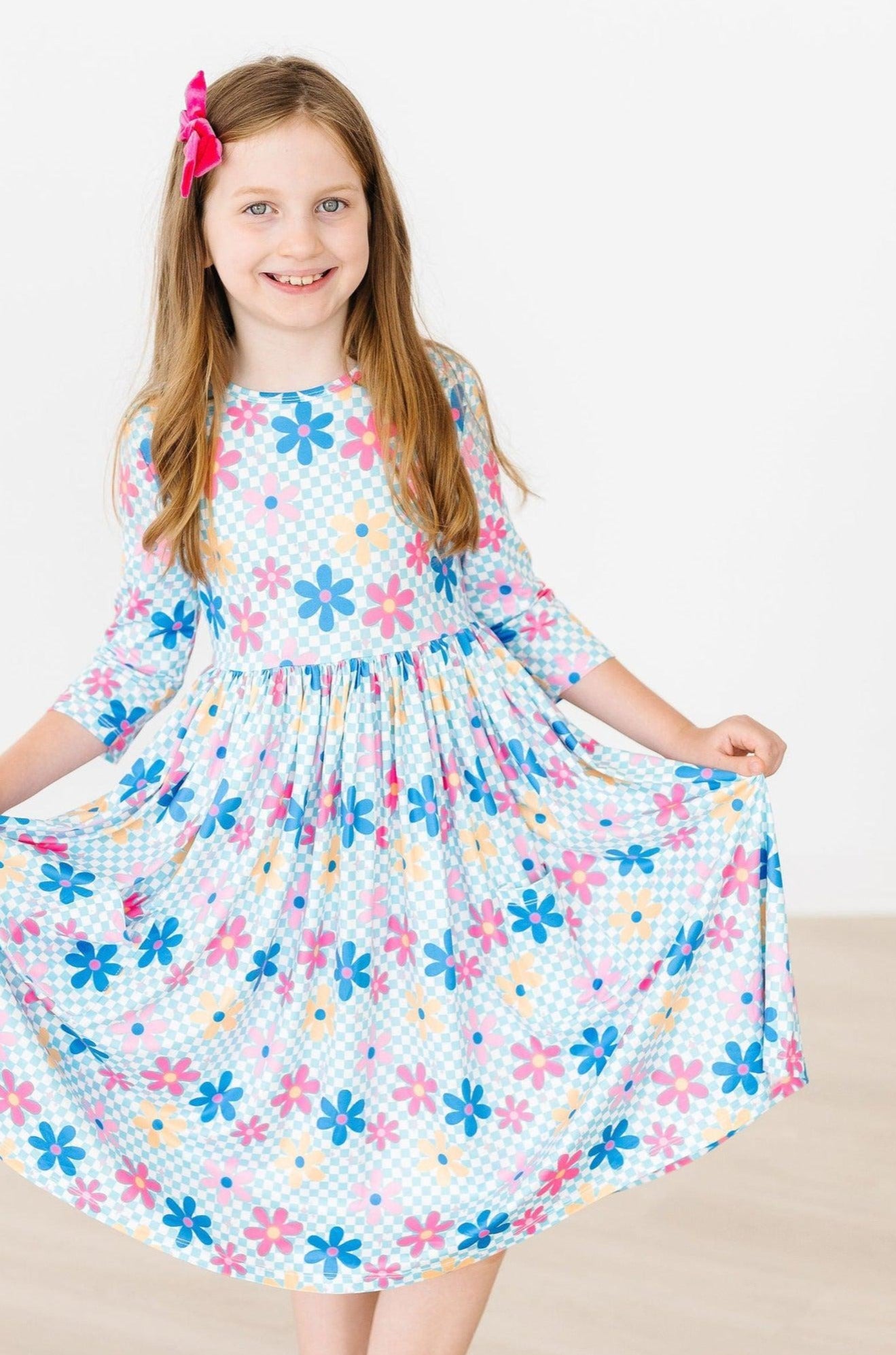 Young girl wearing a floral dress with a white background