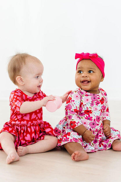 Baby girl wearing Secret Garden floral twirl bodysuit for photos or play

