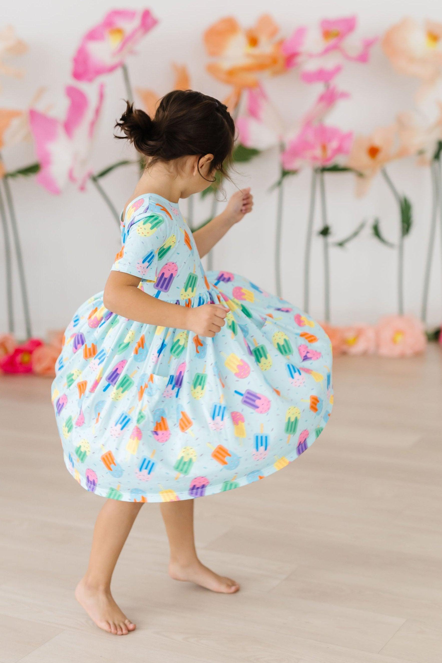 child twirling in sweet treat print dress for birthday party

