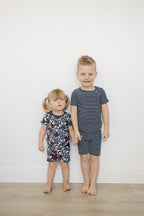 children wearing navy striped and floral americana bamboo print toddler short set against a white wall

