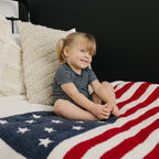 smiling girl wearing navy striped bamboo toddler short set in bedroom

