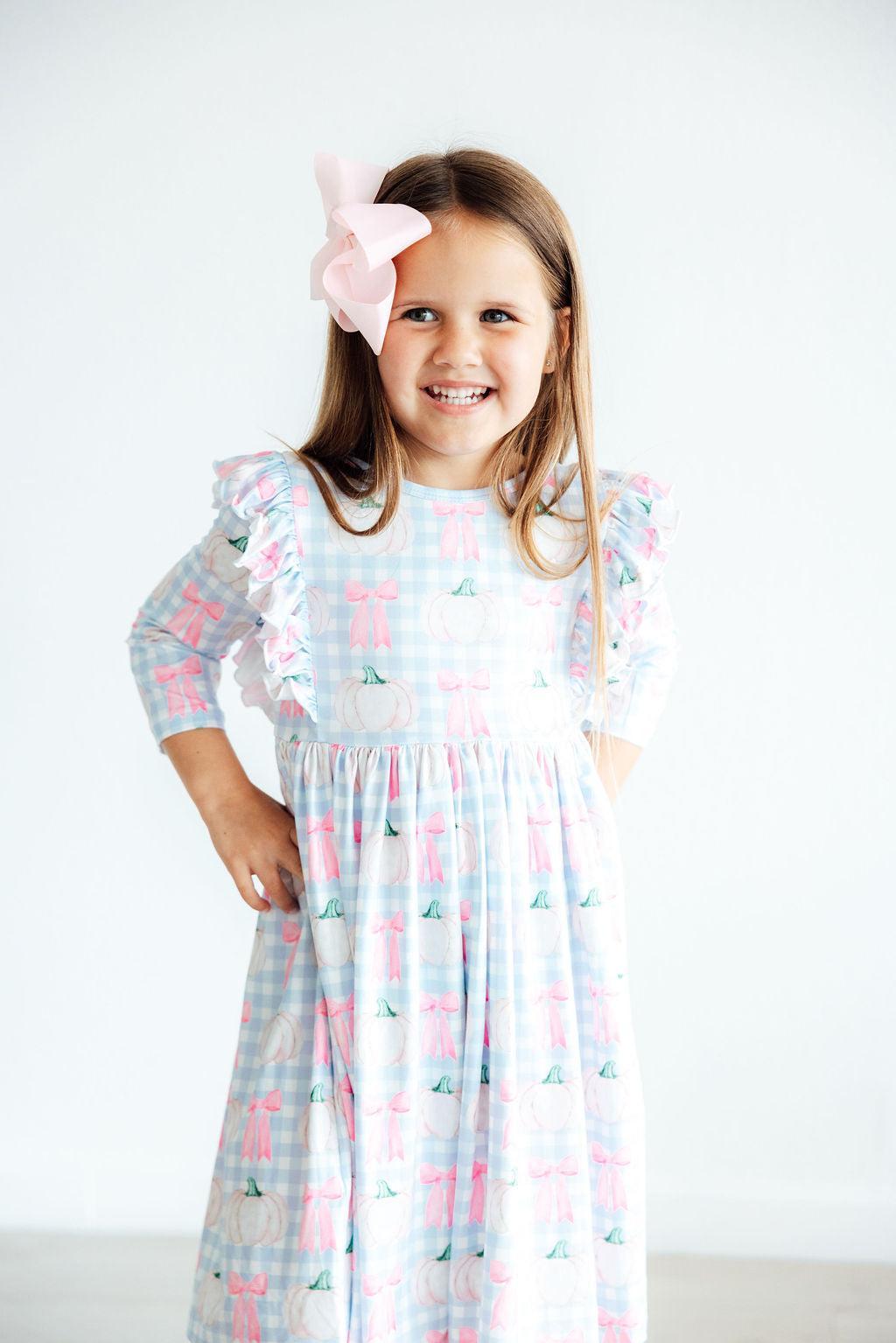 Young girl wearing a floral dress with a white background